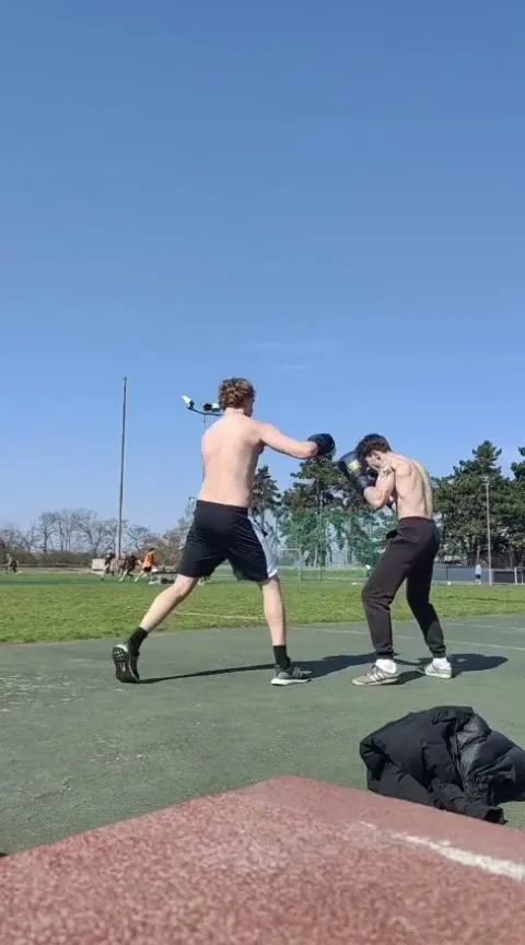 Max practising sparring with another boxer outdoors